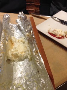 Grilled feta served in an interesting wooden u-shaped bowl.