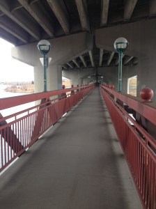 A pedestrian bridge under a highway 